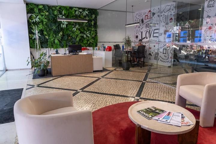 Receção do piso 0 da KW Area, com balcão de ripas de madeira e calçada portuguesa
