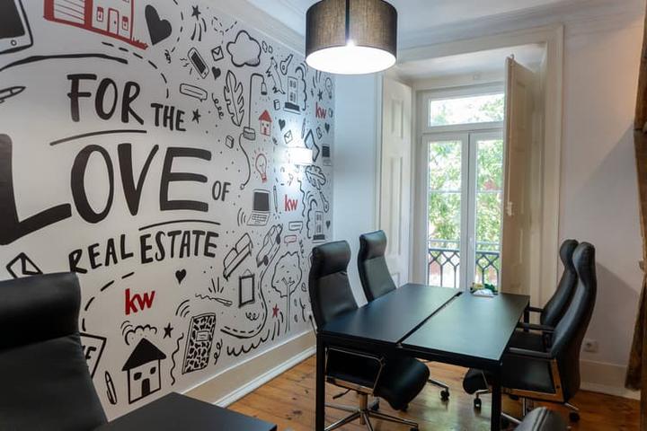 Sala de reuniões do piso 1 da KW Area com janela aberta para as árvores