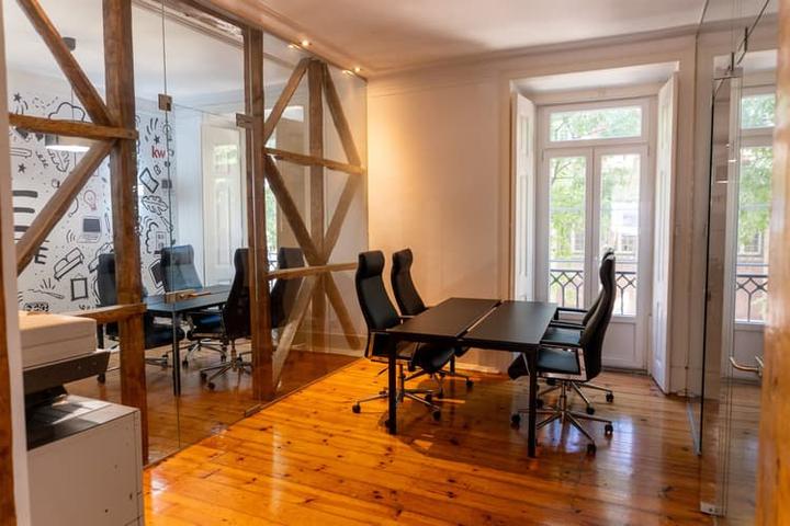 Sala de reuniões do piso 1 da KW Area, com soalho de madeira e vigas à vista